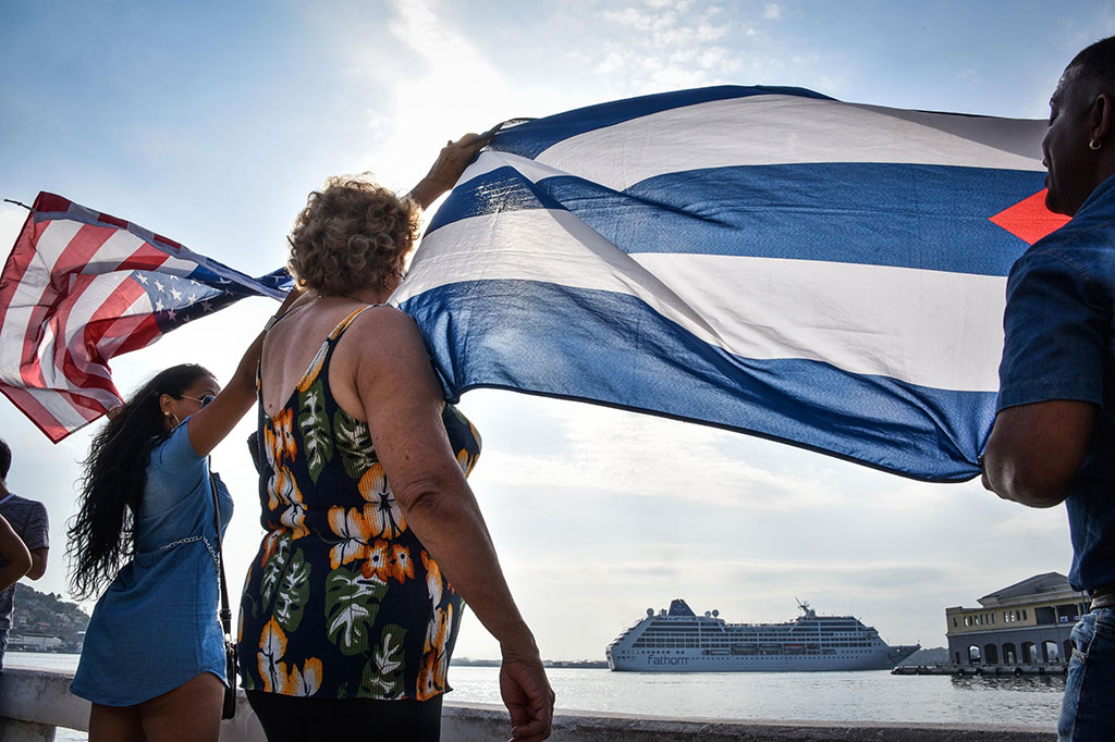 Warga melambaikan bendera AS dan Kuba saat menyambut kedatangan kapal pesiar Adonia di Pelabuhan Havana.