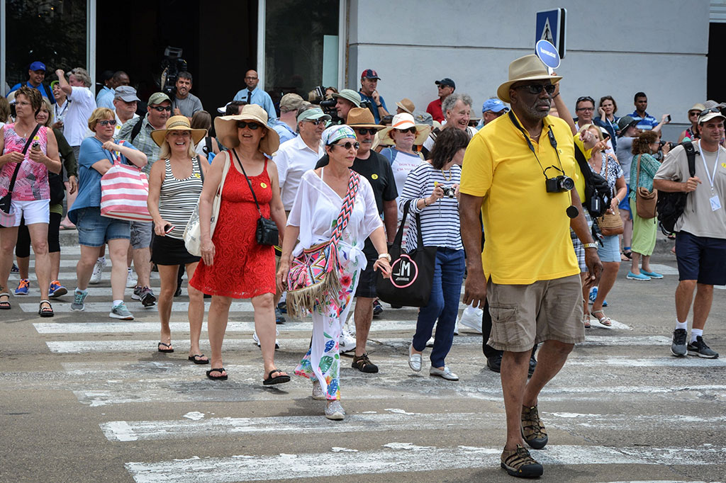 Para penumpang Adonia berjalan keluar dari pelabuhan.