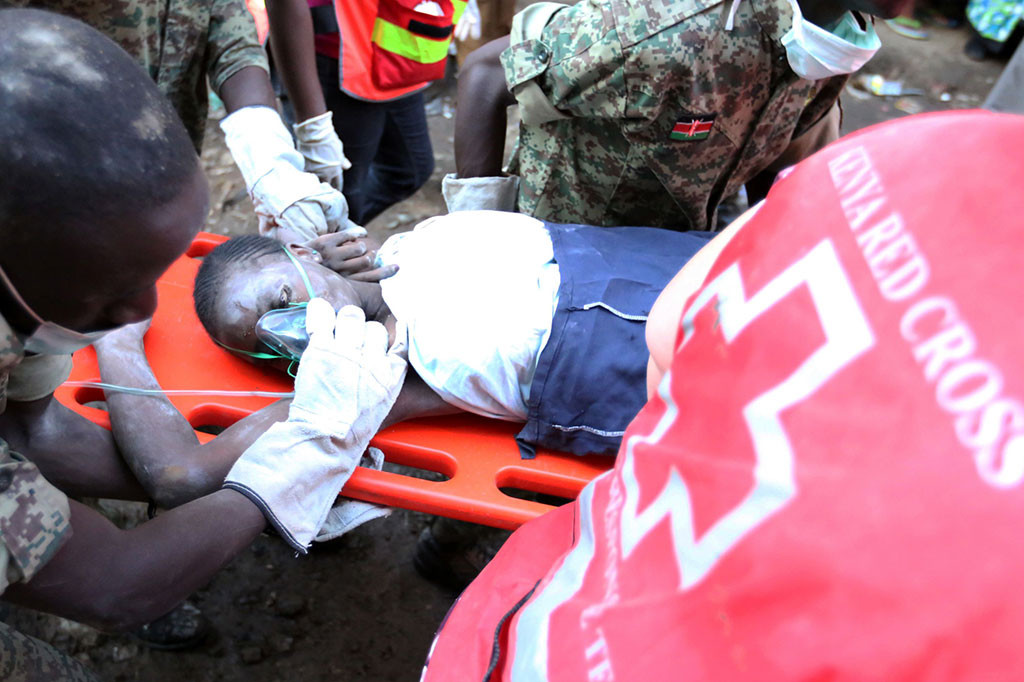 Petugas mengevakuasi seorang wanita yang terperangkap selama enam hari di puing-puing bangunan yang runtuh di daerah Huruma, Nairobi, Kenya, Kamis (5/5/2016).