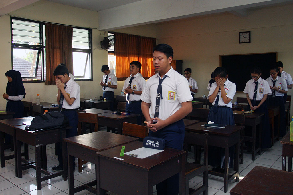Siswa berdoa sebelum mengerjakan soal pada hari pertama UN tingkat SMP di SMPN 41 Jakarta. UN SMP dilaksanakan serentak di seluruh Indonesia pada 9-12 Mei.