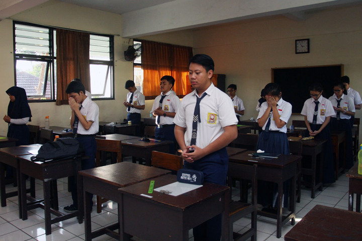 Siswa berdoa sebelum mengerjakan soal pada hari pertama UN tingkat SMP di SMPN 41 Jakarta. UN SMP dilaksanakan serentak di seluruh Indonesia pada 9-12 Mei.