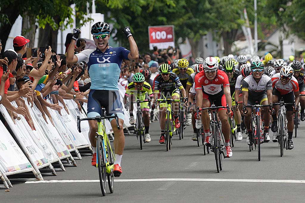 Atlet balap sepeda Korea dari tim LX-IIBS Cycling Team Shin Donghyun meluapkan kegembiraan saat menyentuh garis finish.