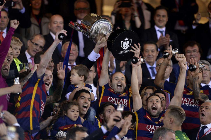 Kapten Andres Iniesta dikelilingi para pemain Barca mengangkat tinggi-tinggi trofi Piala Raja Spanyol yang baru saja mereka raih.