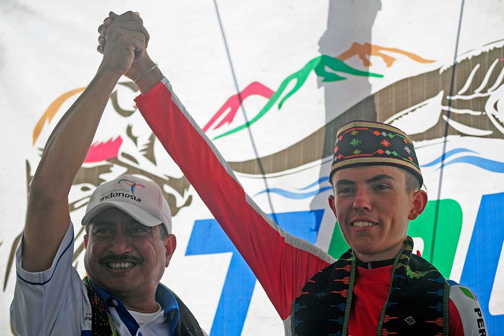 Menteri Pariwisata Arief Yahya mengangkat tangan bersama pembalap asal Inggris dari tim Terengganu Cycling Team Malaysia Daniel White House ketika penganugerahan juara.