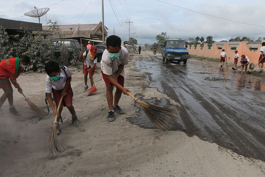 Siswa SD Bersihkan Jalan dari Debu Vulkanik Sinabung