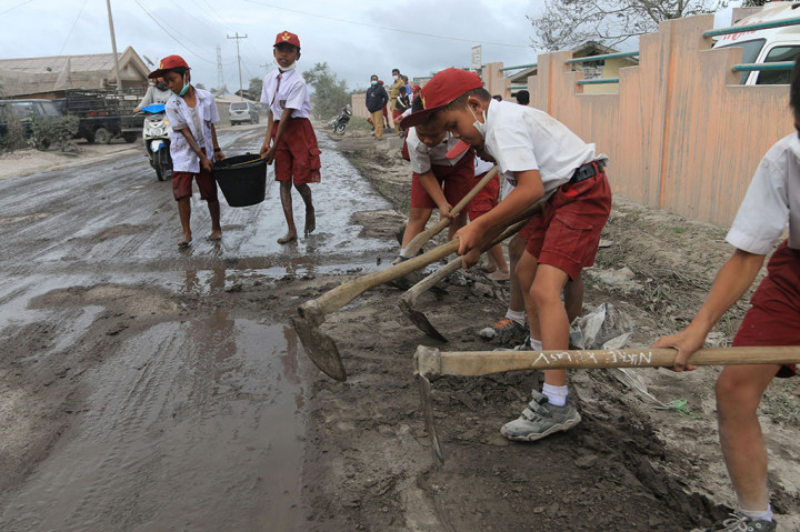 Siswa SD Bersihkan Jalan dari Debu Vulkanik Sinabung