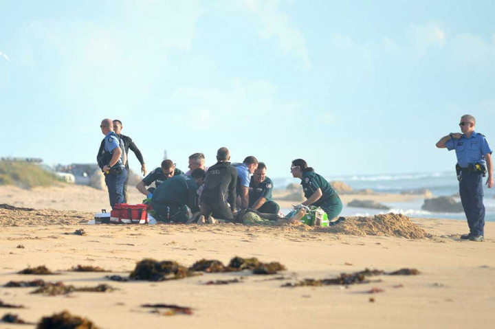 Petugas memberikan pertolongan kepada peselancar Ben Gerring yang digigit hiu di Falcon Beach.