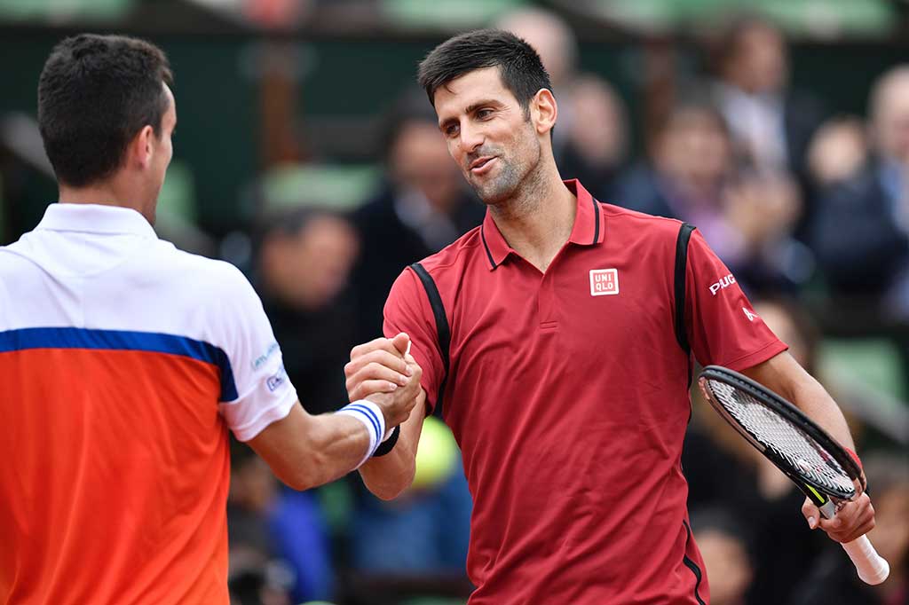 Djokovic berjabat tangan dengan Bautista usai pertandingan 16 besar yang dimenangkannya.
