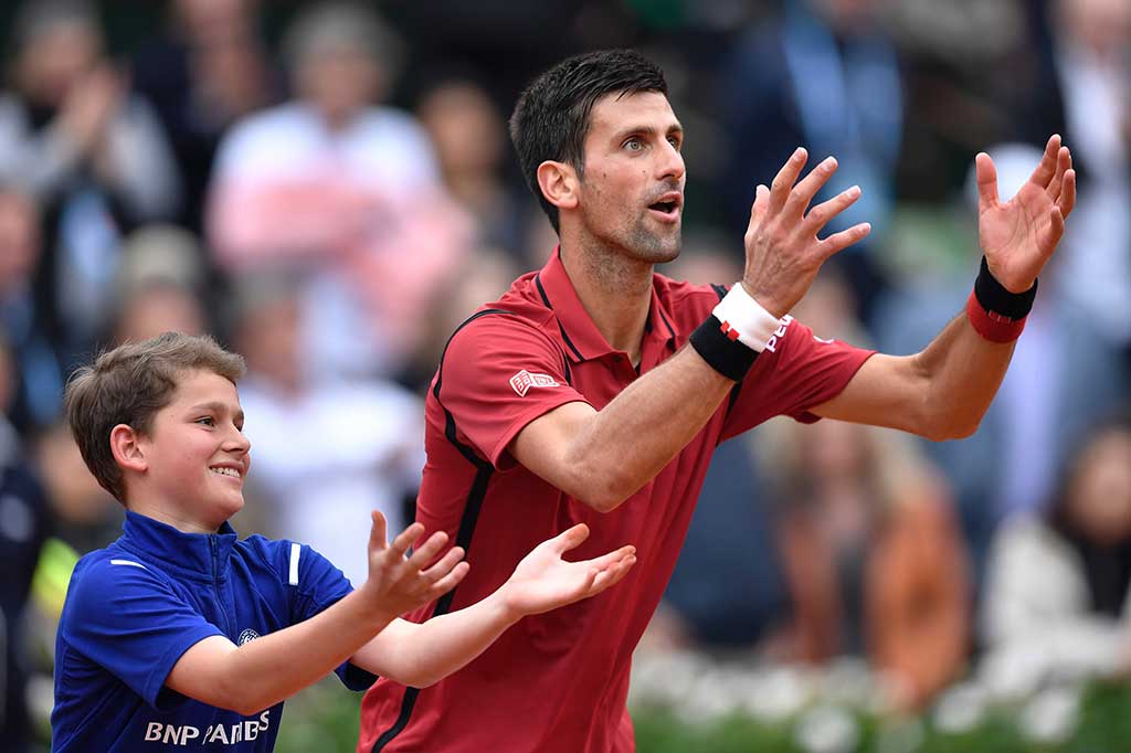Djokovic mengajari seorang ball boy merayakan kemenangan selepas laga.