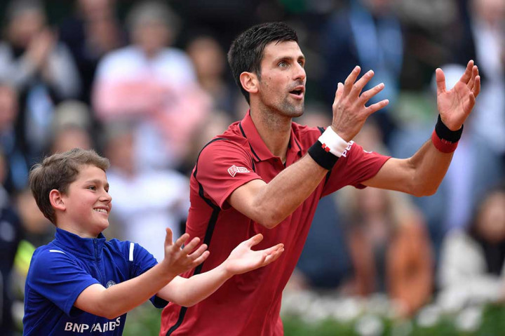 Djokovic mengajari seorang ball boy merayakan kemenangan selepas laga.