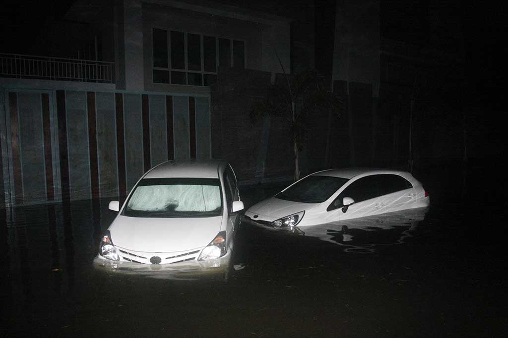 Dua mobil milik warga terendam banjir yang menggenangi kawasan Perumahan Pantai Mutiara, Jakarta.