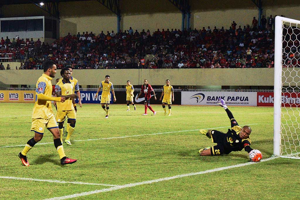 Penjaga gawang Barito Putra, Adhitya Harlan menepis bola dari gempuran pesepak bola Persipura Jayapura dalam lanjutan kompetisi Torabika Soccer Championship (TSC) 2016 di Stadiun Mandala Jayapura.