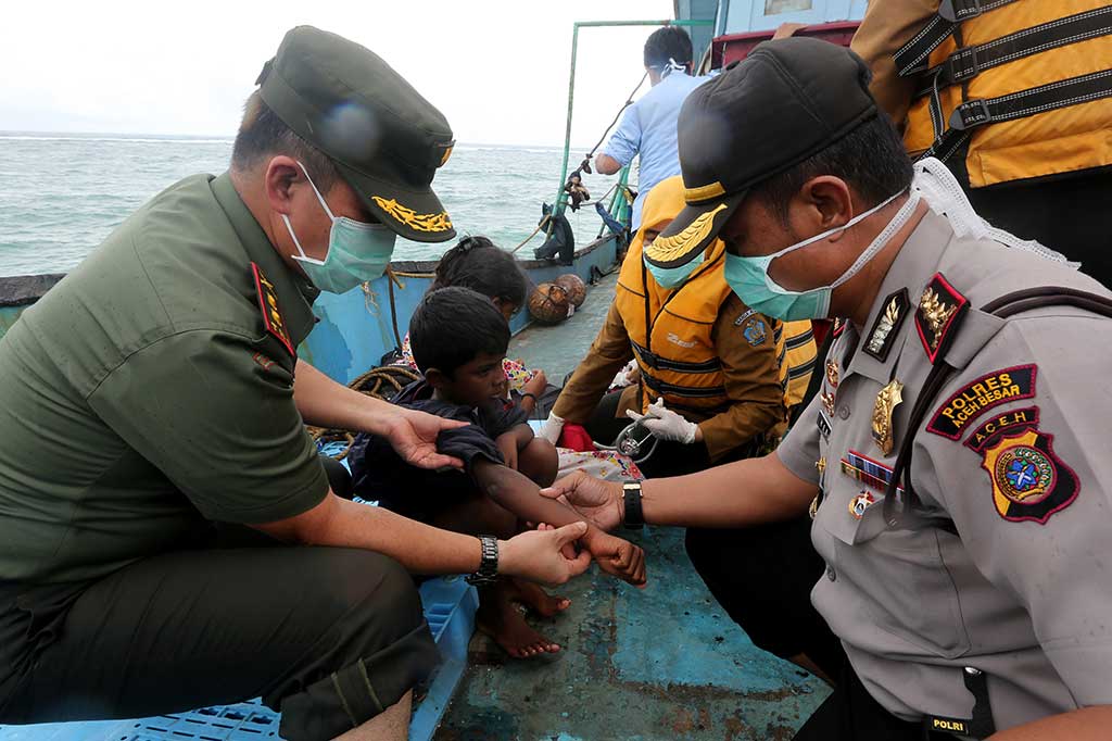 Petugas kesehatan dibantu aparat TNI/Polri memeriksa kesehatan imigran Srilanka di atas kapal.