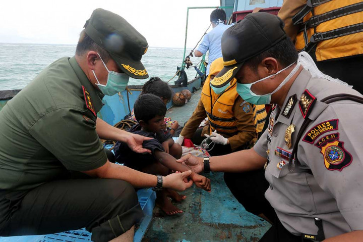 Petugas kesehatan dibantu aparat TNI/Polri memeriksa kesehatan imigran Srilanka di atas kapal.