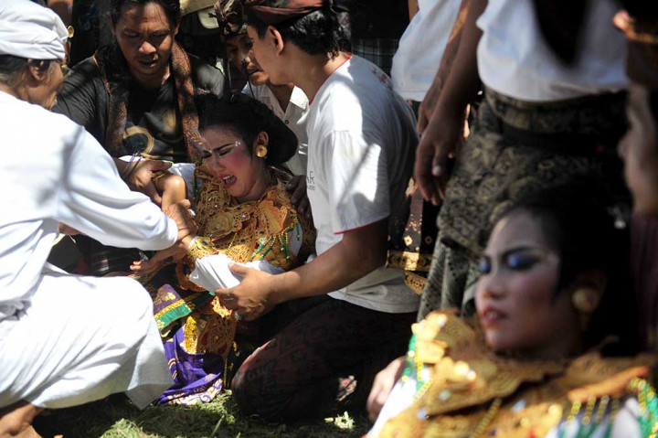 Warga berupaya menenangkan penari yang kesurupan.