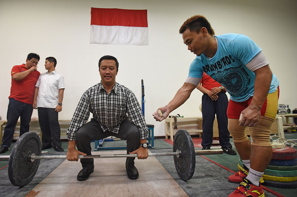  Menpora Imam Nahrawi mencoba mengangkat beban disaksikan Chief de Mission Indonesia untuk Olimpiade Rio, Raja Sapta Oktohari dan lifter Eko Yuli Irawan. 