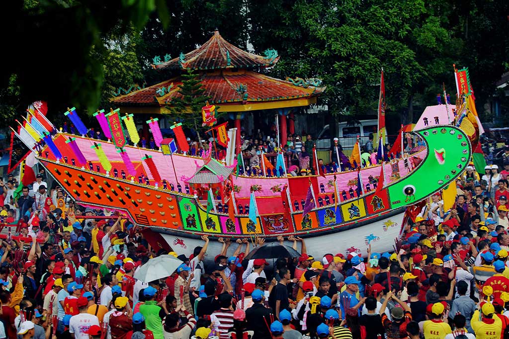 Warga mengarak replika tongkang menuju tempat pembakaran.