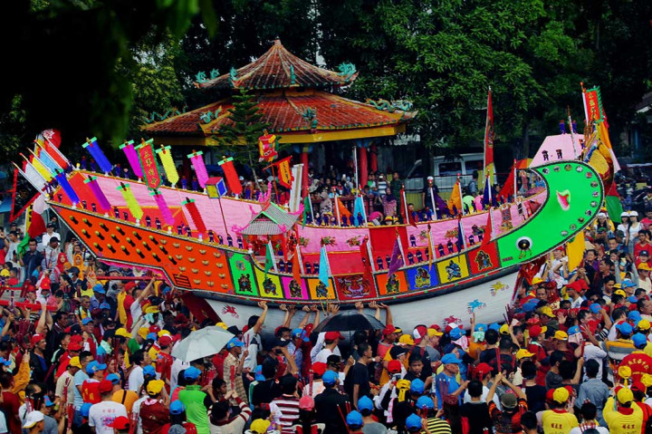 Warga mengarak replika tongkang menuju tempat pembakaran.