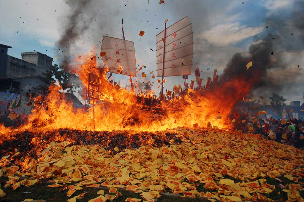 Warga menyaksikan pembakaran kapal tongkang pada puncak acara ritual Bakar Tongkang.