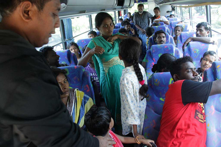 Petugas membantu imigran Sri Lanka menempati bus pemerintah Aceh saat pemberangkatan ke penampungan imigrasi di pendopo gubernur Aceh, Banda Aceh, Rabu (22/6/2016).