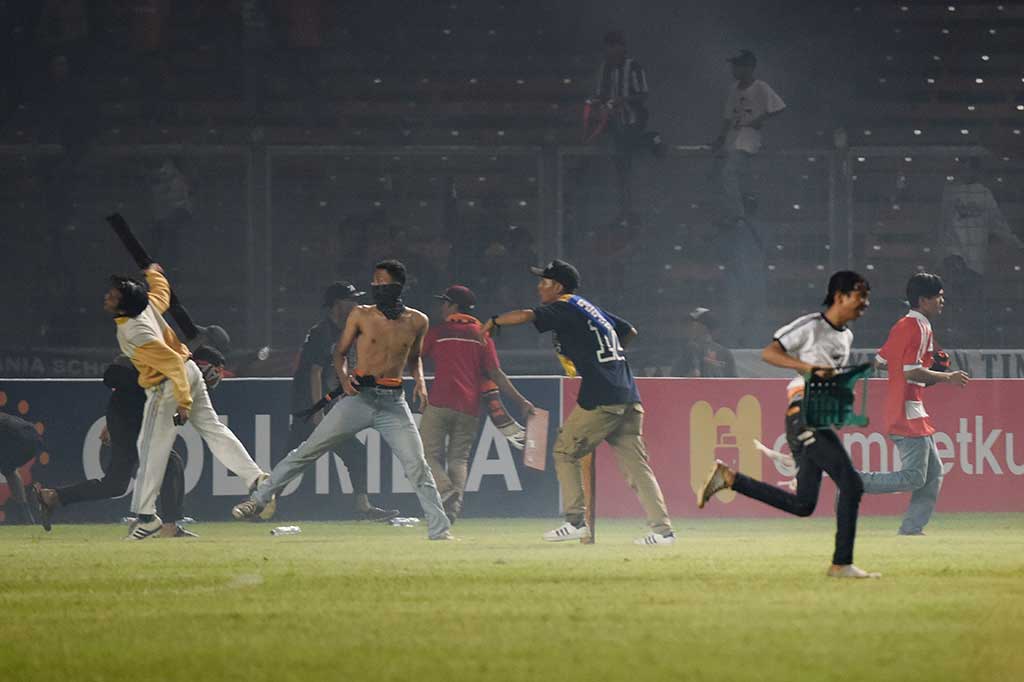 Suporter Persija Jakarta melempari petugas kepolisian ketika terlibat kericuhan pada laga Torabika Soccer Championship di Stadion Utama Gelora Bung Karno.