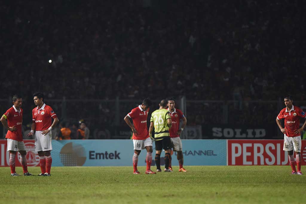 Pemain Persija Jakarta terdiam di lapangan usai pertandingan melawan Sriwijaya FC dihentikan.