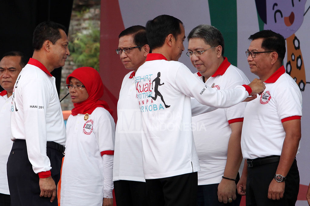 Presiden Jokowi menyematkan pin penghargaan Institut Penggiat Anti Narkoba kepada Direktur Utama BRI Asmawi Syam dan sejumlah penggiat anti narkoba lainnya. 