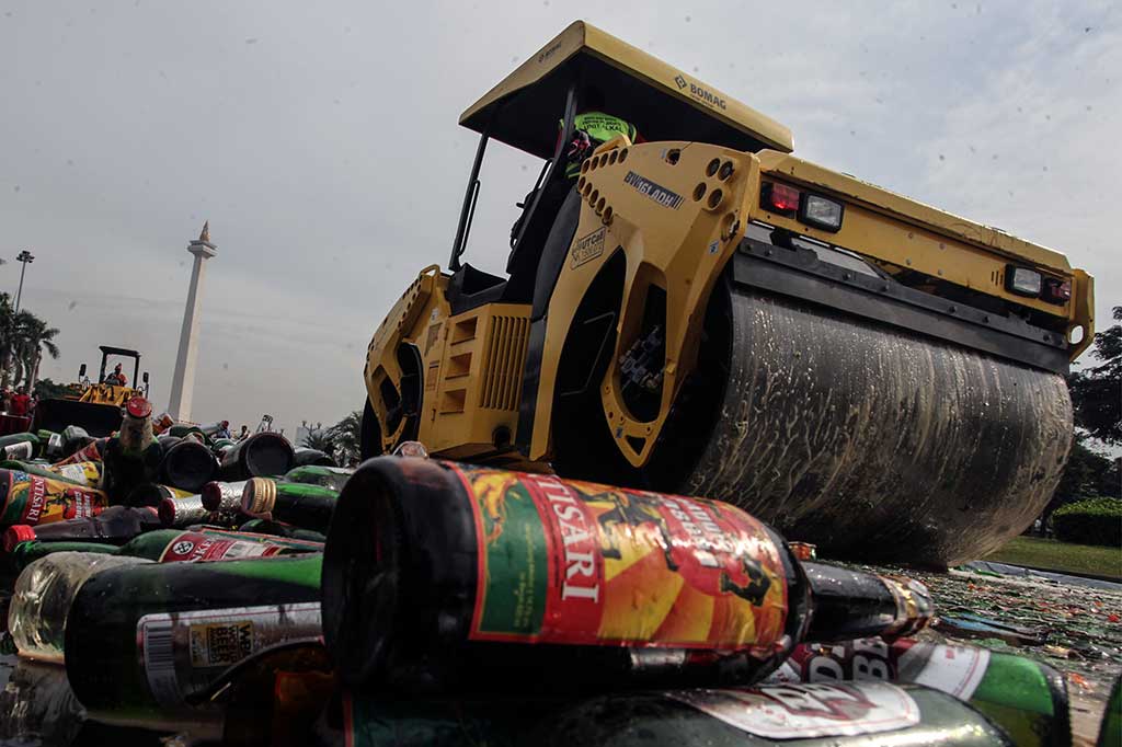 Operator alat berat memusnahkan ribuan minuman keras hasil operasi minuman beralkohol ilegal di kawasan Monas.