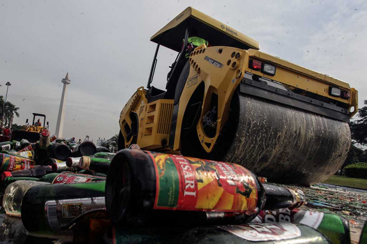Operator alat berat memusnahkan ribuan minuman keras hasil operasi minuman beralkohol ilegal di kawasan Monas.