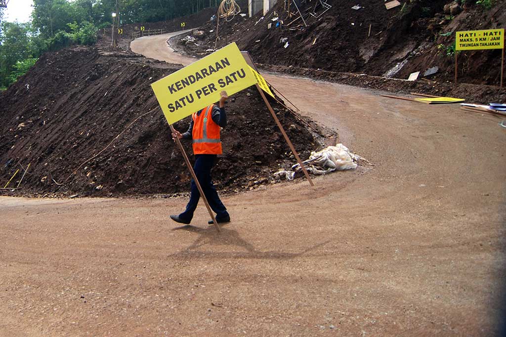 Petugas memasang rambu lalu lintas di ruas jalan alternatif Tol Bawen-Salatiga di Pabelan, Kabupaten Semarang.