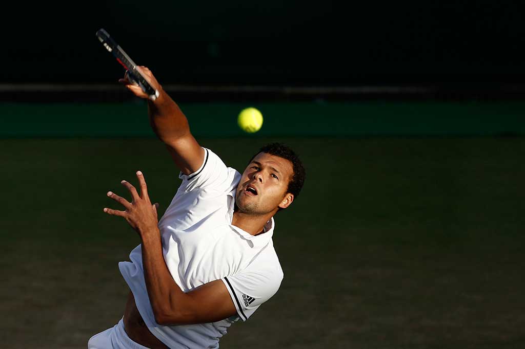 Tsonga melancarkan servis ke arah Isner.