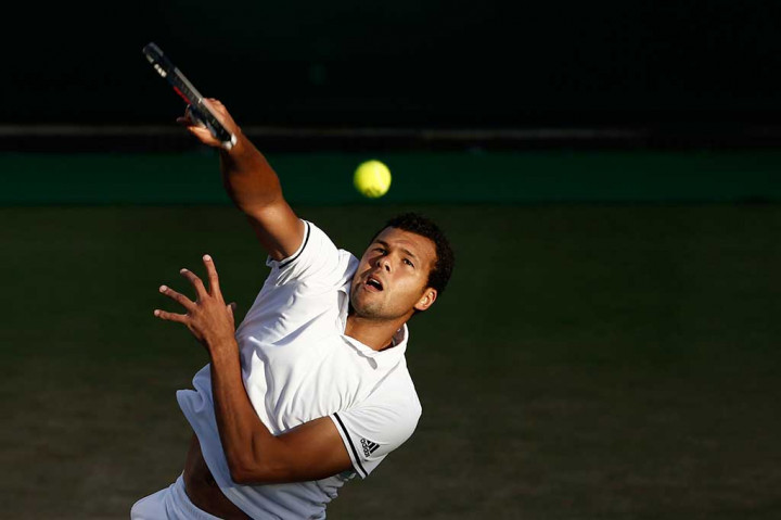 Tsonga melancarkan servis ke arah Isner.
