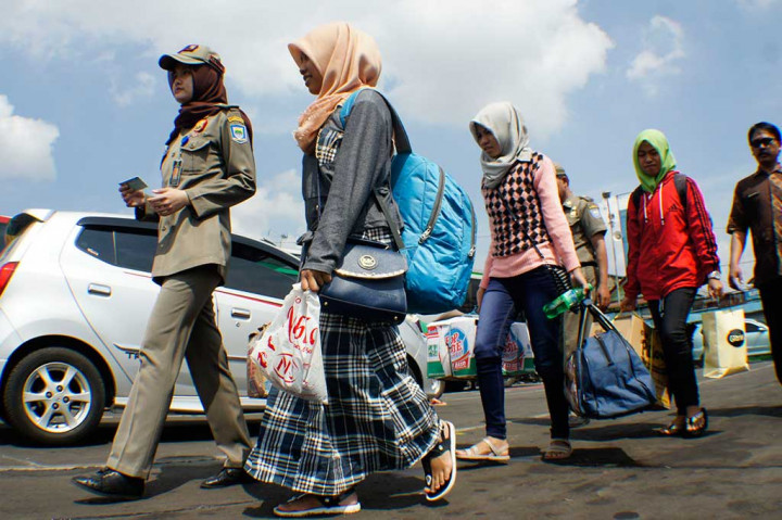 Petugas Disdukcapil Kota Bandung (kiri) membawa beberapa pendatang usai diperiksa kelengkapan identitasnya dalam Operasi Yustisi di Terminal Cicaheum, Bandung.