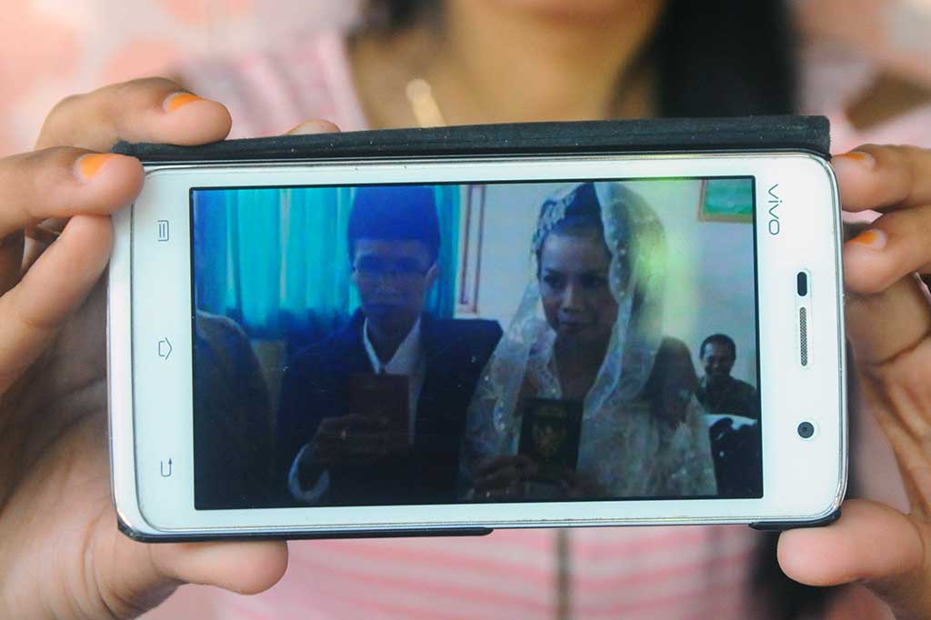 Heniyati menunjukkan foto pernikahannya dengan Suwarti alias Efendi Saputra.