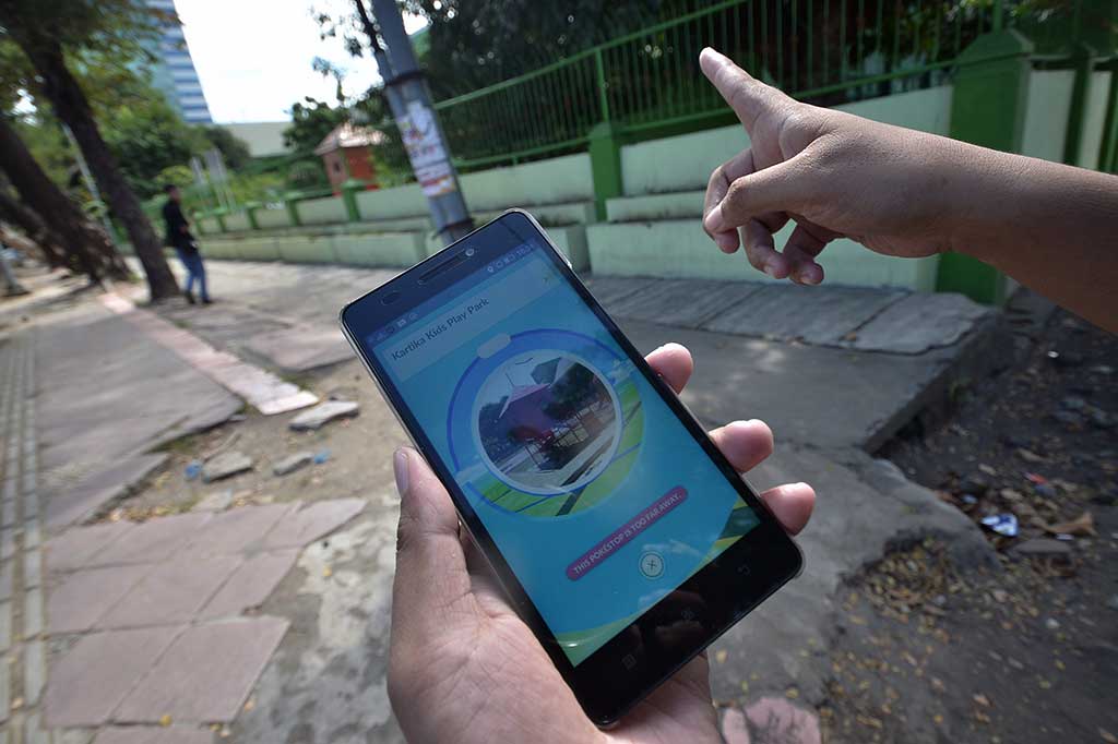 Penggemar game berburu Pokemon di layar androidnya, di Makassar, Sulawesi Selatan, Jumat (15/7/2016).