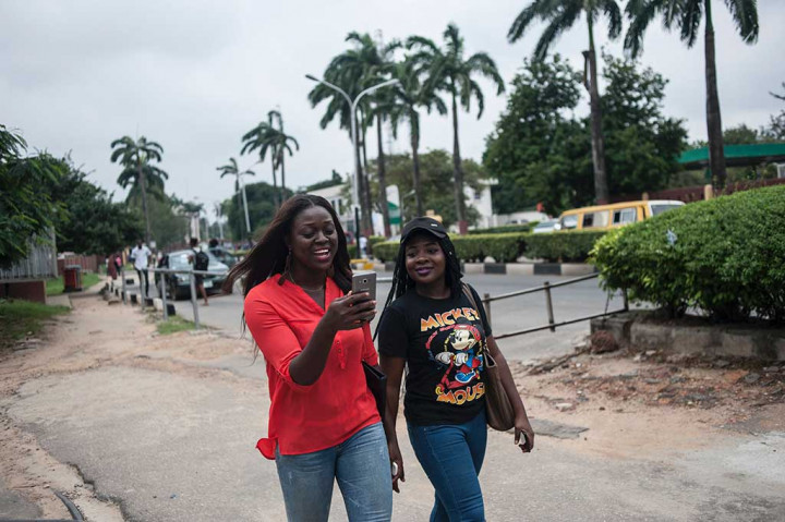 Dua perempuan Nigeria tengah berburu monster Pokemon di kampus Universitas Lagos, Kamis (14/7/2016).