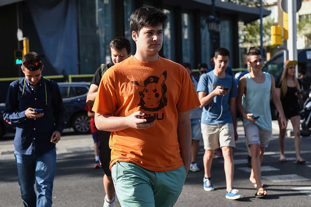 Gamers tengah berburu monser Pokemon di Barcelona, Kamis (14/7/2016).