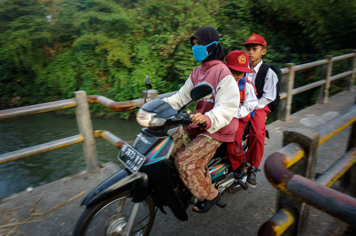 Ibu mangantar anak berangkat ke sekolah melintasi jembatan di Dusun Kiringan, Canden, Bantul, DI Yogyakarta, Senin (18/7). ANTARA/Hendra Nurdiyansyah