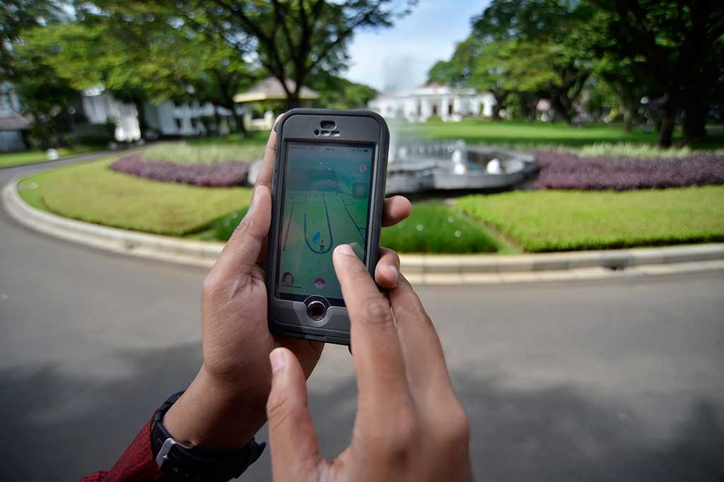 Pengunjung mencoba permainan 'Pokemon Go' di halaman Istana Negara, Jakarta, Rabu (20/7/2016). 