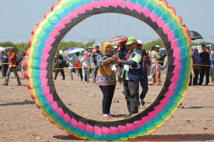 Pengunjung berusaha menerbangkan layang-layang milik peserta dari Thailand.