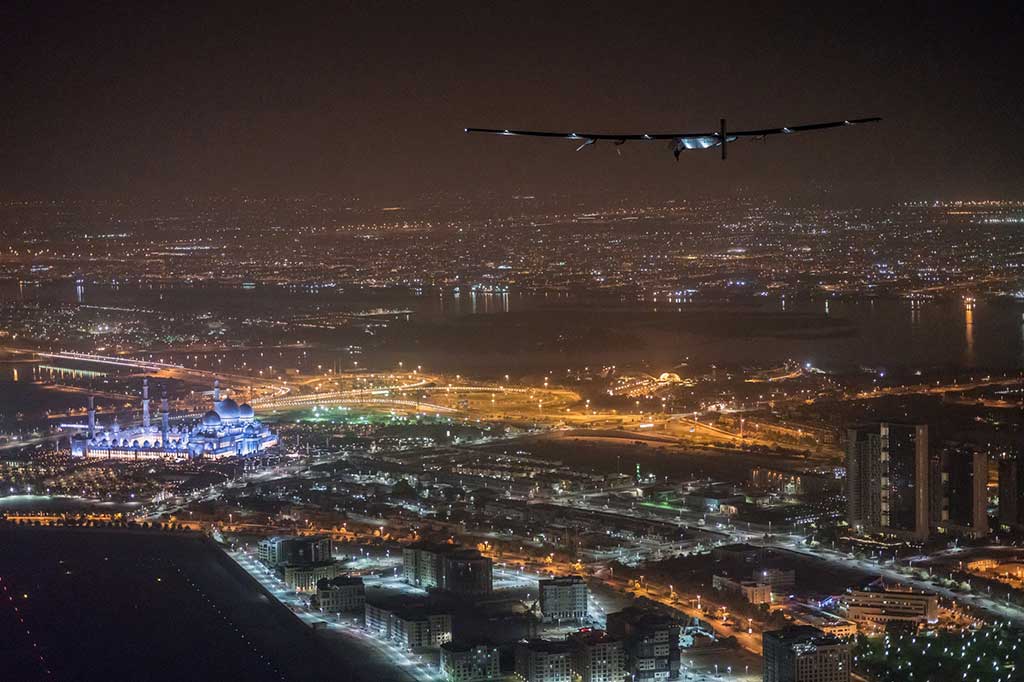 Solar Impulse 2 saat akan mendarat di Bandara Abu Dhabi, dengan latar belakang Masjid Sheikh Zayed.
