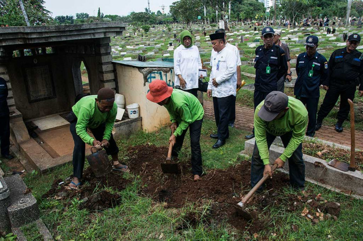 Pekerja membongkar makam diduga fiktif di TPU Menteng Pulo.