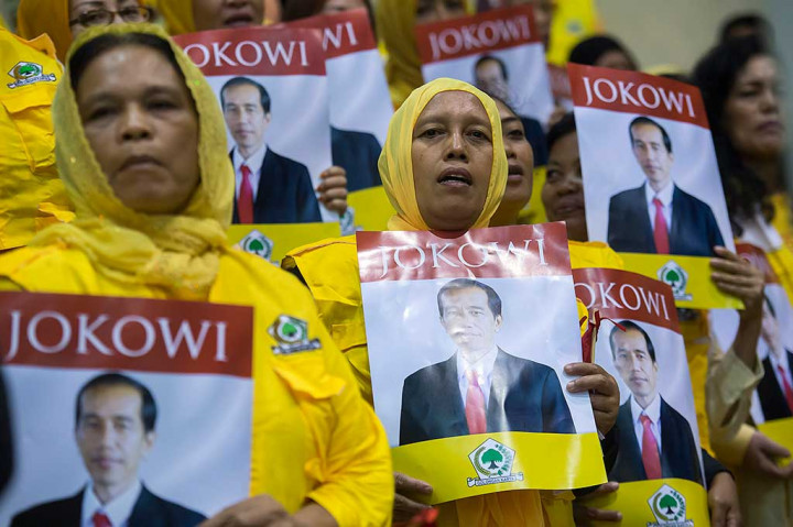 Sejumlah kader Partai Golkar membawa poster bergambar Presiden Jokowi.