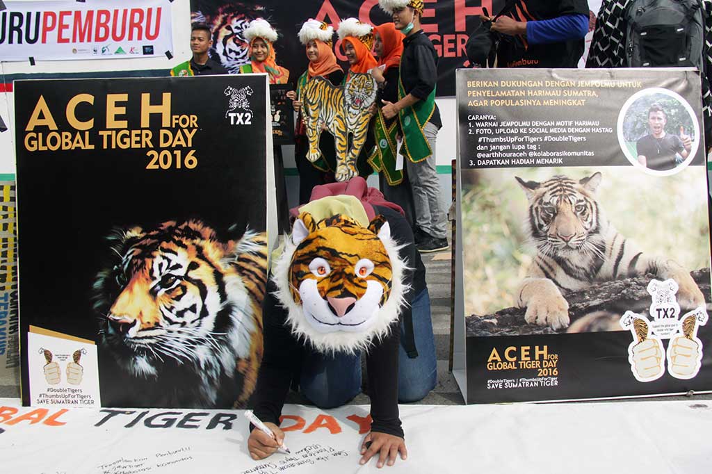 Aktivis Komunitas Aceh membubuhkan tanda tangan pada selembar kain putih mengampanyekan penghentian perburuan dan perdagangan harimau.
