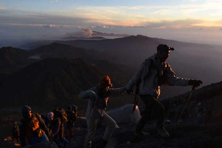 Pendaki mendaki Gunung Semeru dengan latar Gunung Bromo.