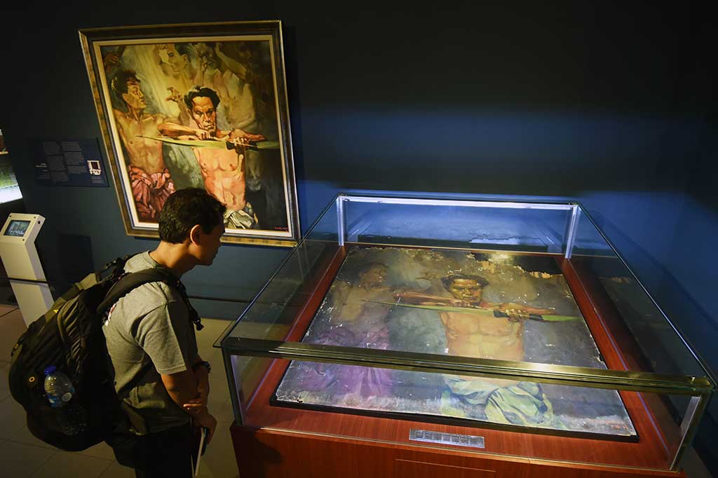 Pengunjung memperhatikan lukisan karya Henk Ngantung berjudul 'Memanah' tahun 1943.
