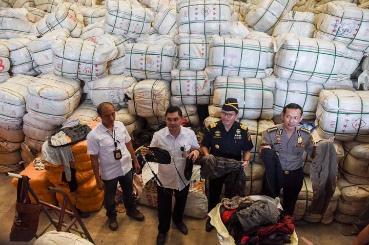 Dirkrimsus Polda Metro Jaya Kombes Fadil Imran (kedua kiri) bersama Kabid Humas Polda Metro Jaya Kombes Awi Setiyono (kanan) dan Direktur Penindakan dan Penyidikan Direktorat Jenderal Bea Cukai Kementerian Keuangan Harry Mulya menunjukkan pakaian impor bekas di sebuah gudang penyimpanan di kawasan Pulogebang, Jakarta, Senin (1/8/2016).