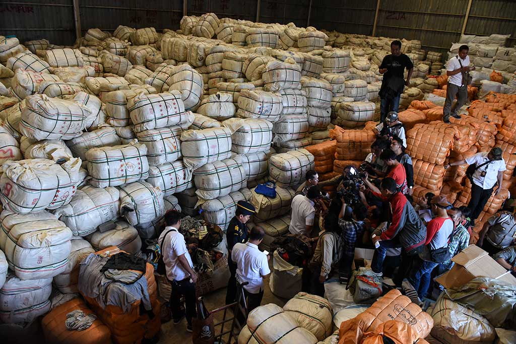 Wartawan mengambil gambar di dalam gudang penyimpanan pakaian impor bekas ilegal di kawasan Pulogebang.