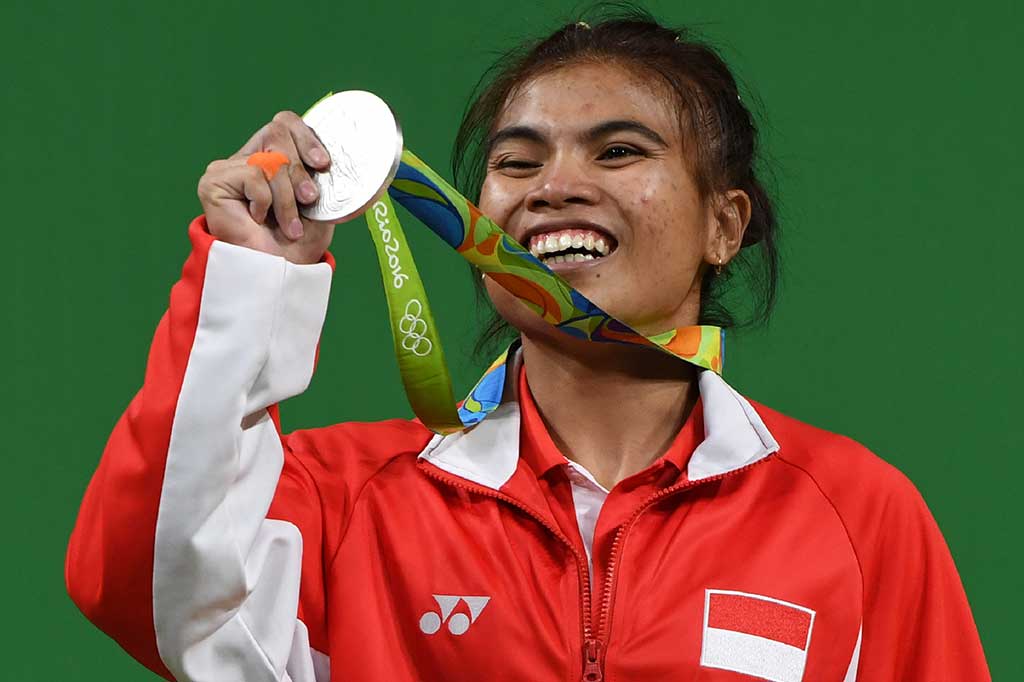 Sri Wahyuni memamerkan medali perak yang diraihnya.