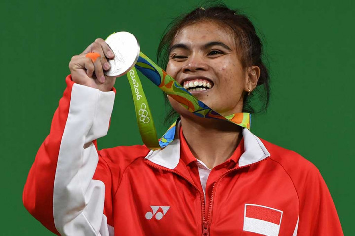 Sri Wahyuni memamerkan medali perak yang diraihnya.